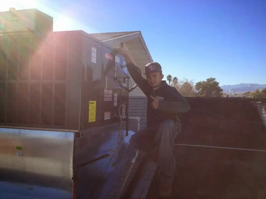 HVAC technician performing Boiler Repair on a rooftop unit in Scottsbluff